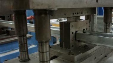 Iron cutting machine in a profile factory.A factory producing iron profiles. Profile material production machine in a modern plant. Factory assembly line line, automatic machine.