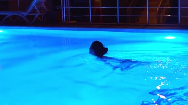 Young Woman Swims Alone Neon Lit Pool Night Woman Swimming — Vídeo de stock