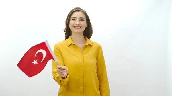 stock image Happy young woman waving Turkish flag on white background.Smiling young woman isolated on white background celebrating with Turkey flag. Celebration of special days of countries.