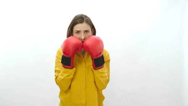ビジネス生活における困難への対処 白い背景に隔離されたボクシングの手袋を持つ若い女性 ボクシングの手袋で運動する若い女性は 緊張してカメラをパンチ 強い女性の肖像 — ストック写真