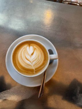 Cappuccino with Heart-Shaped Latte Art on a Metal Table clipart