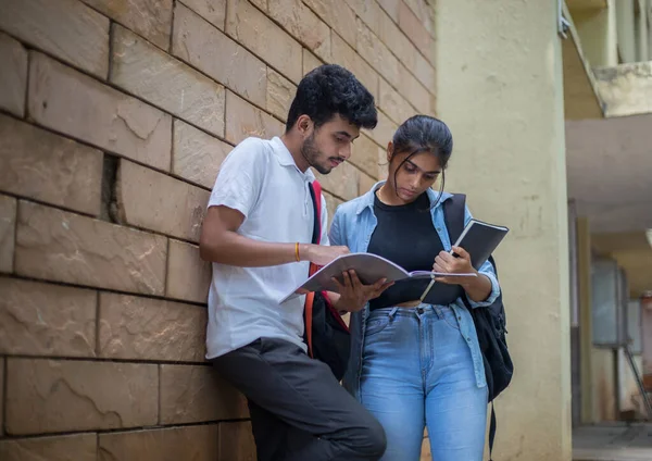 Farklı etnik kökenlerden üniversite öğrencileri bir kitap tutuyor ve kampüste yaptıkları çalışmaları tartışıyorlar.. 