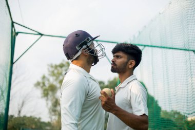 Vurucu kriket oynarken atıcıya kızgın. Kaliteli fotoğraf. Vurucu sahada Bowler 'a karşı. Sportmenlik kavramı. İki oyuncu birbirine kızar ve öfkelenir.