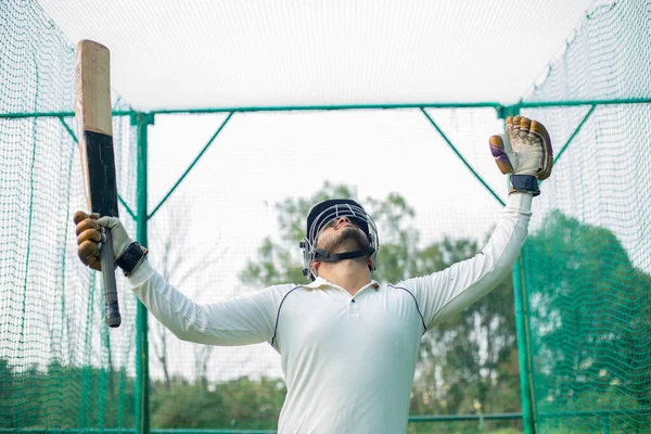 Kriket oyuncusu başarısını kutluyor. Batsman maçta iyi skor yaptıktan sonra başarısını kutluyor. Mutlu hissetme, odaklanma, sportmenlik kavramı.