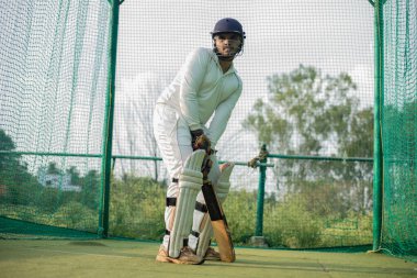 Cricket Batsman bowlingci için bekliyor. Oyuncu ağlarda daha fazla pratik yapmaya hazır. Odaklanmış oyuncu oynamaya hazır, yüksek kalite fotoğraf