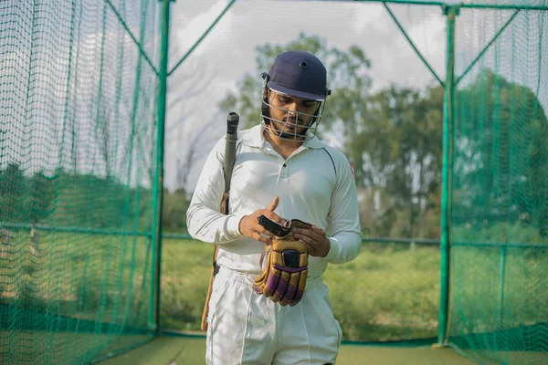 cricket player wearing hand gloves, ready to do practice in nets. Batsman ready to face ball and bowler on field. The gloves offer excellent protection and enhanced grip.