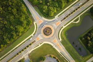 Aerial view of road roundabout intersection with moving cars traffic. Rural circular transportation crossroads.