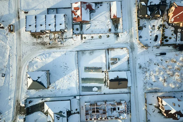 stock image Aerial view of private homes with snow covered roofs in rural suburbs town area in cold winter.