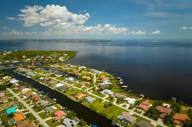 Florida yakınlarındaki deniz kıyısındaki uzak banliyölerdeki kırsal özel evlerin havadan görüntüsü körfez kıyısında yeşil bitki örtüsü olan sulak alanlar. Tropikal bölge kavramında doğaya yakın yaşamak.