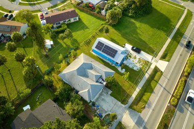 Temiz ekolojik elektrik enerjisi üretmek için sıralanmış mavi güneş fotovoltaik panelleri olan hava manzaralı çatı. Sıfır emisyon kavramı ile yenilenebilir elektrik.