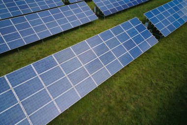 Temiz elektrik enerjisi üretmek için birçok sıra güneş fotovoltaik paneli bulunan sürdürülebilir büyük elektrik santralinin havadan görünüşü. Sıfır emisyon kavramı ile yenilenebilir elektrik.