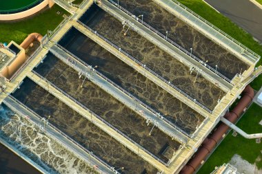 Aerial view of modern water cleaning facility at urban wastewater treatment plant. Purification process of removing undesirable chemicals, suspended solids and gases from contaminated liquid.