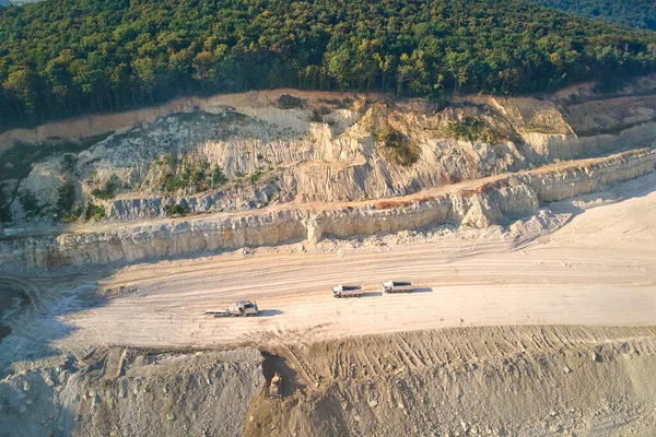 建筑行业用挖掘机和倾卸卡车露天采挖石灰石的空中景观 — 图库照片