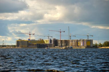 Yüksek konutlu apartman şantiyesinde vinç kaldırma. Deniz kıyısında gayrimenkul geliştirme.