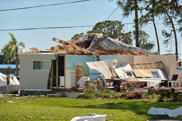 Severely damaged house after hurricane Ian in Florida mobile home residential area. Consequences of natural disaster.