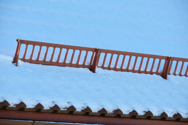 屋根の上にセラミック製の帯状疱疹で覆われて冬の安全のための雪ガード 建物のタイル張り — ストック写真