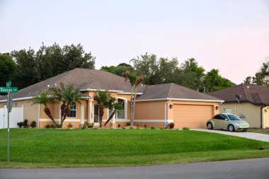 Geniş garajın önüne park edilmiş bir araba. Yeni modern Amerikan evinin beton yolu üzerinde çift kapı..