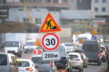 Yol çalışmaları trafik işaretlerini uyardı. Şehir caddesinde inşaat çalışması ve yavaş hareket eden arabalar..