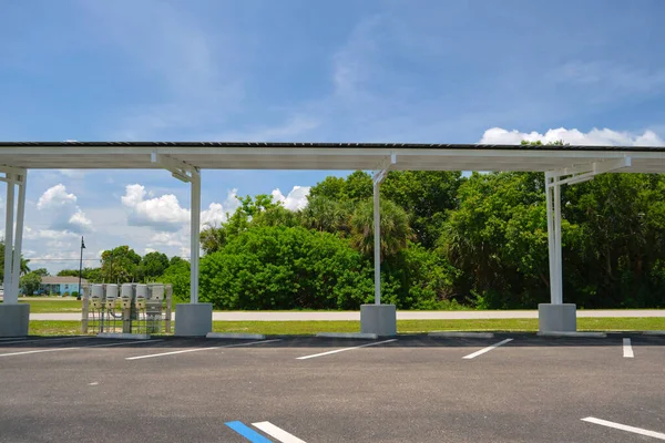 stock image Solar panels installed as shade roof over parking lot for parked electric cars for effective generation of clean electricity. Photovoltaic technology integrated in urban infrastructure.