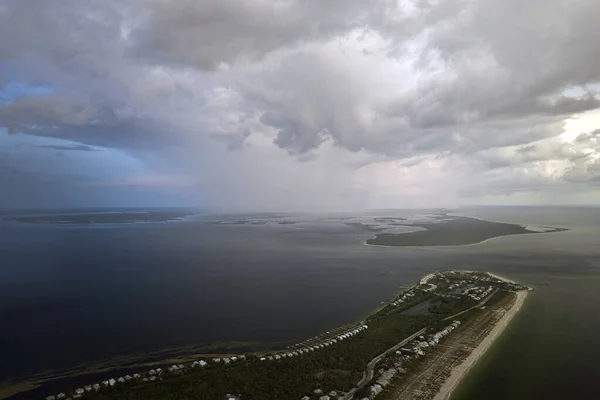 Aerial view of tropical storm approaching over rich neighborhood with expensive vacation homes in Boca Grande, small town on Gasparilla Island in southwest Florida.