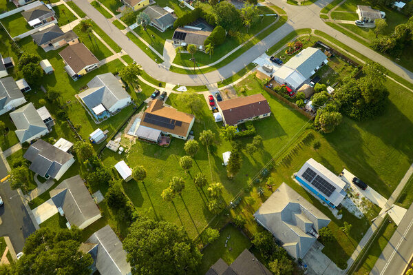 Aerial landscape view of suburban private houses between green palm trees in Florida quiet rural area.