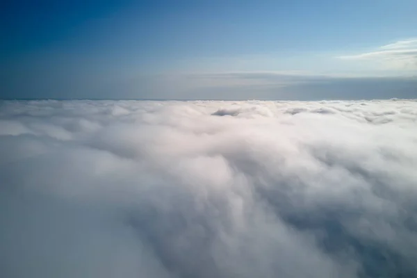 Aerial view from high altitude of earth covered with puffy rainy clouds forming before rainstorm.