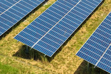 Temiz elektrik enerjisi üretmek için sıra sıra güneş fotovoltaik panelleri olan sürdürülebilir büyük elektrik santralinin havadan görünüşü. Sıfır emisyonlu yenilenebilir elektrik kavramı.