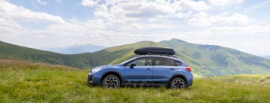 Blue off road car on mountain trail. Traveling by auto, adventure in wildlife, expedition or extreme travel on SUV automobile.