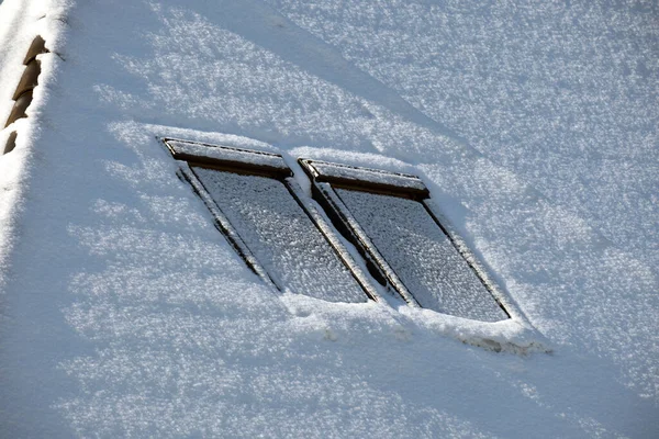 寒い冬に雪で覆われた屋根裏部屋の窓が付いている家の屋根の上の閉鎖 冬の天候の建物のタイル張りのカバー — ストック写真