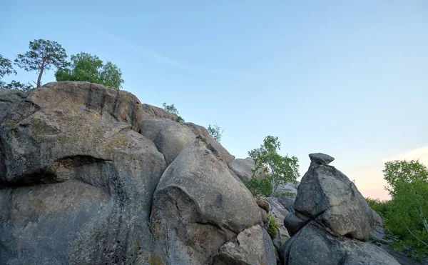 stock image Huge rocky boulder formations high in mountains with growing trees on summer sunny day.