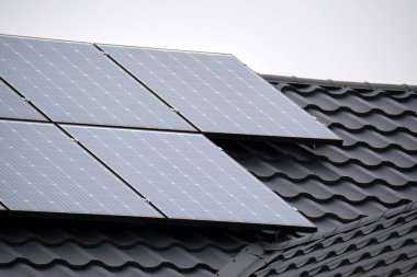 Şehrin kırsal kesimlerinde temiz ekolojik elektrik enerjisi üretmek için güneş fotovoltaik panellerle kaplı özel bir çatı. Özerk ev kavramı.