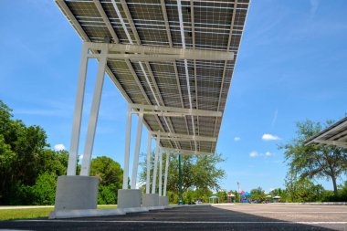 Solar panels installed over parking lot canopy shade for parked cars for effective generation of clean energy.