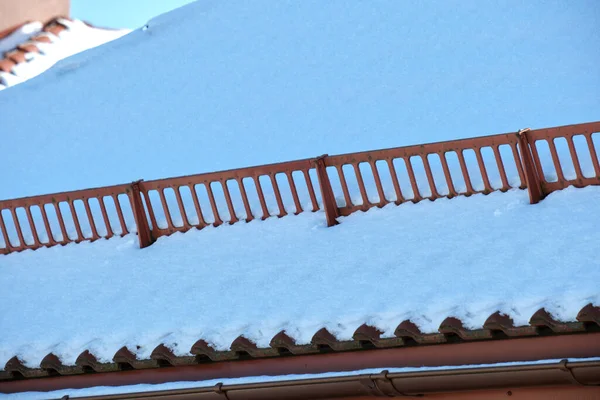 鉄の帯状疱疹で覆われた家の屋根の上に冬の安全のための雪ガード 建物のタイル張り — ストック写真