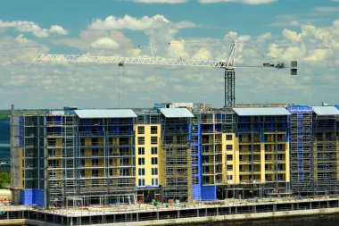 Tower lifting cranes at high residential apartment buildings construction site. Real estate development.
