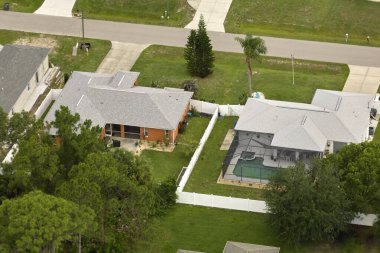 Florida 'nın sakin yerleşim bölgesinde yeşil palmiye ağaçları arasında özel evleri olan küçük bir Amerikan banliyö manzarası..