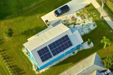 Banliyö bölgesinde temiz ekolojik elektrik enerjisi üretmek için güneş fotovoltaik panellerle kaplı çatısı olan bir ev. Özerk konut kavramı.
