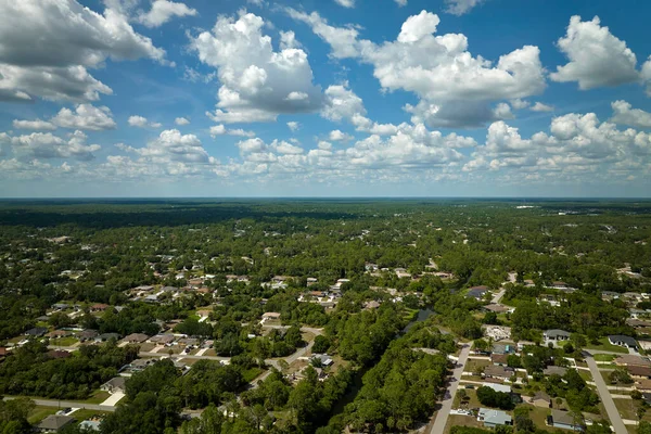 Aerial view of small town America suburban landscape with private homes between green palm trees in Florida quiet residential area.