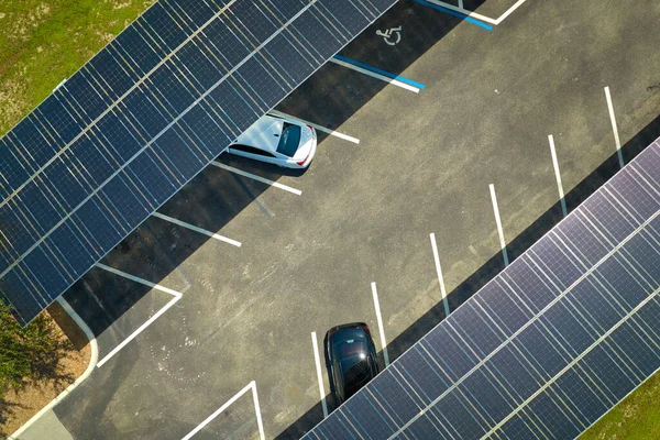 Aerial view of solar panels installed as shade roof over parking lot for parked cars for effective generation of clean electricity. Photovoltaic technology integrated in urban infrastructure.