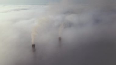 Kömür santrali yüksek borular siyah zehirli duman yayıyor. Beyaz sisli havada yukarı doğru hareket ediyorlar. Fosil yakıt kavramına sahip elektrik enerjisi üretimi.