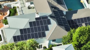 Banliyö bölgesinde temiz ekolojik elektrik enerjisi üretmek için çatısı güneş fotovoltaik panellerle kaplı pahalı bir Amerikan konutu. Özerk konut kavramı.