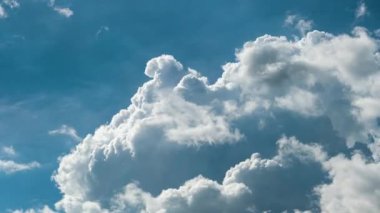 Yazın mavi gökyüzünde fırtınadan önce beyaz tüylü kümülonimbus bulutları oluşuyor. Hareket eden ve değişen bulutlu hava durumu.
