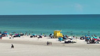 Sarasota, ABD 'de kalabalık Siesta Key plajının yüksek açılı görüntüsü. Birçok insan tatillerde okyanus suyunda yüzer ve sıcak Florida güneşinde dinlenir..