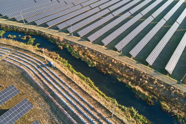 stock image Aerial view of large sustainable electrical power plant with rows of solar photovoltaic panels for producing clean ecological electric energy. Renewable electricity with zero emission concept.