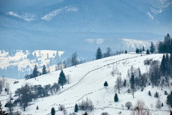 冬天的风景 小村子里的房子夹在冰雪覆盖的森林中寒冷的群山中 — 图库照片