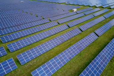 Temiz elektrik enerjisi üretmek için birçok sıra güneş fotovoltaik paneli bulunan sürdürülebilir büyük elektrik santralinin havadan görünüşü. Sıfır emisyon kavramı ile yenilenebilir elektrik.