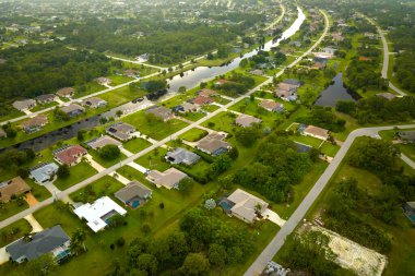 Florida 'nın sakin yerleşim bölgesinde yeşil palmiye ağaçları arasında özel evleri olan küçük bir Amerikan banliyö manzarası..