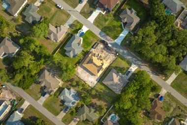 Aerial view of suburban private house wit wooden roof frame under construction in Florida quiet rural area.