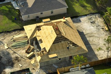 Florida 'nın sakin kırsal kesiminde yapım aşamasında olan banliyö özel evi manzaralı ahşap çatı iskeleti..