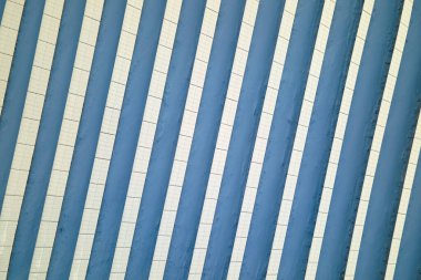 Aerial view of sustainable electrical power plant with solar photovoltaic panels covered with snow in winter for producing clean energy. Concept of low effectivity of renewable electricity in north.