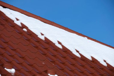 Soğuk kışta evin çatısının üstü karla kaplıydı. Kış mevsiminde binanın kaplamasına döşenmiş.